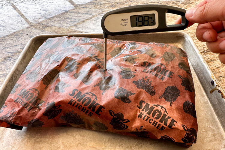 instant read thermometer poked into a wrapped chuck roast