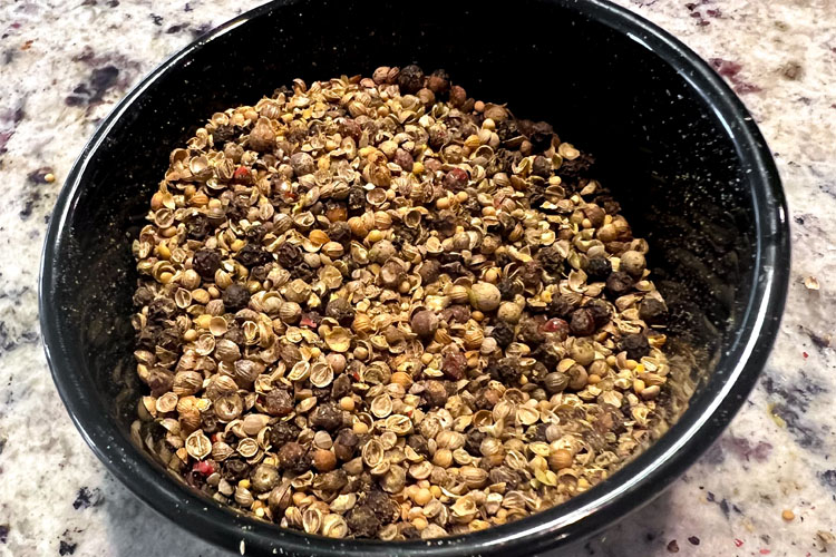 ingredients for pastrami rub in a black bowl pre grind
