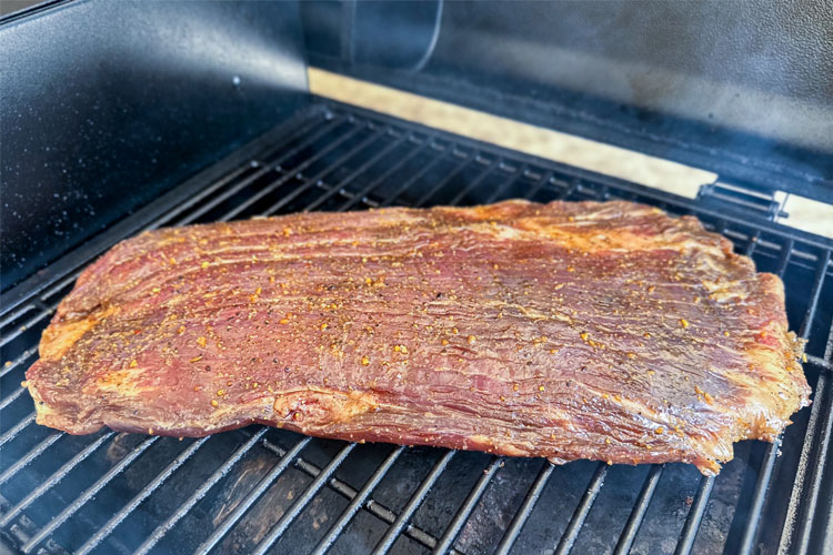 raw flank steak on the grill