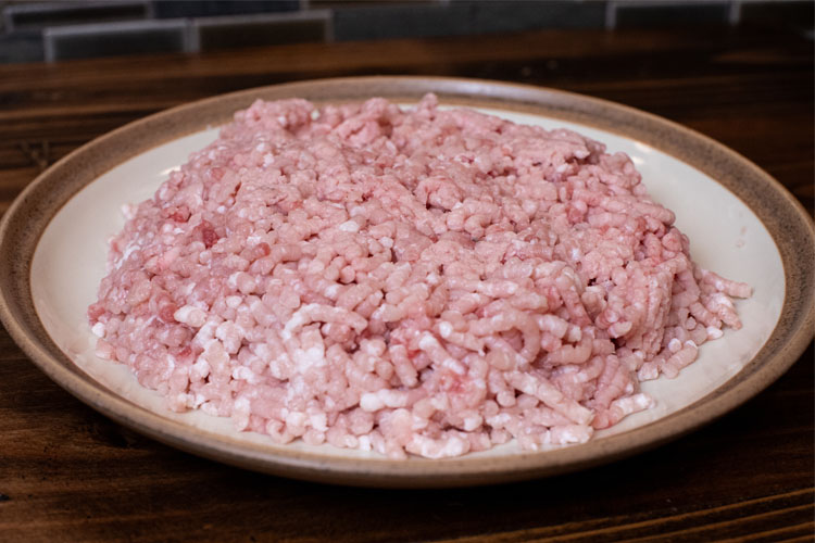 raw ground pork loin on a white plate