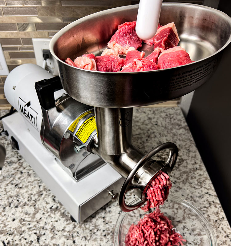 grinder with chunks in the top and ground beef coming out