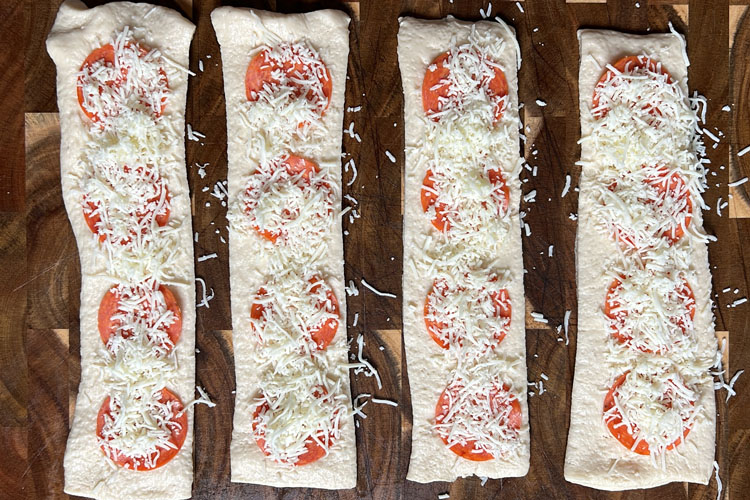 shredded cheese on pizza dough strips