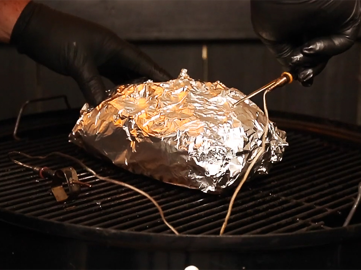 pork butt wrapped in foil with inserted temperature probe