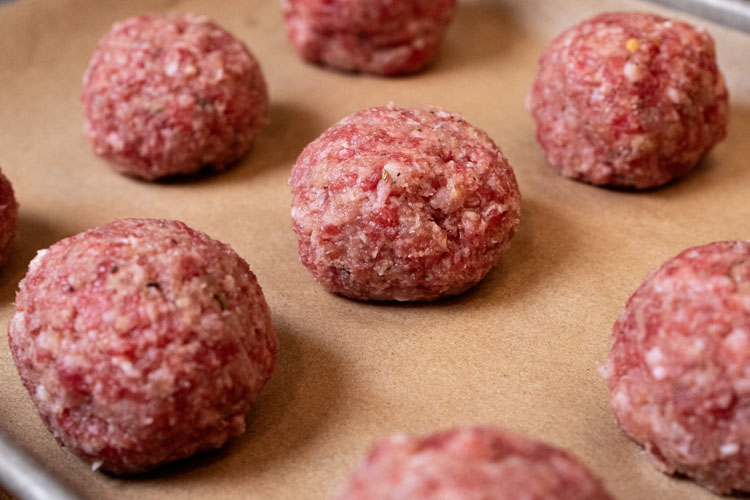raw rolled meatballs on brown paper