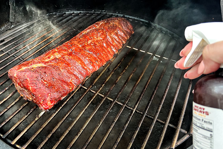 no wrap baby back ribs in smoker being spritzed