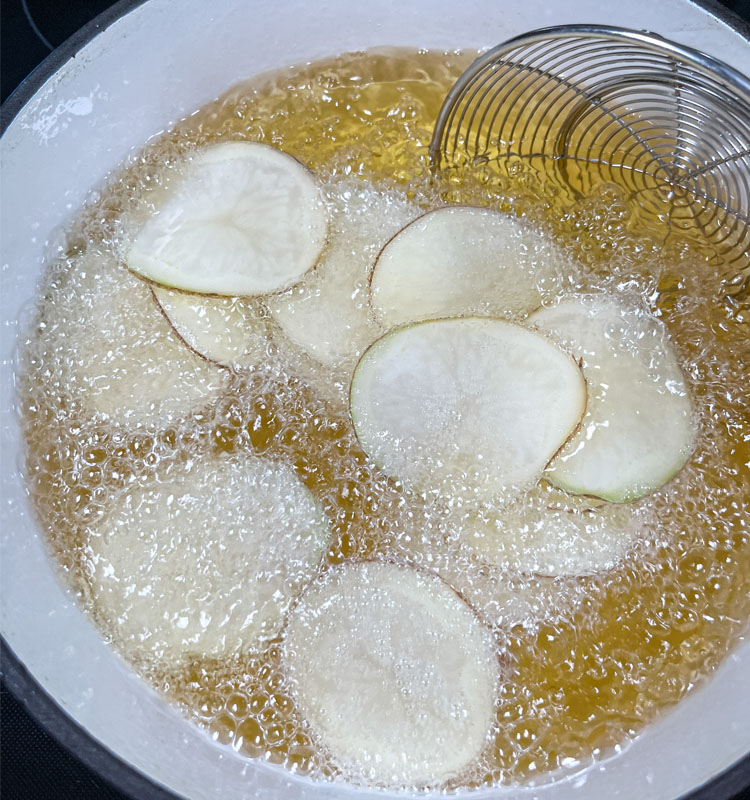raw potatoe slices frying in oil