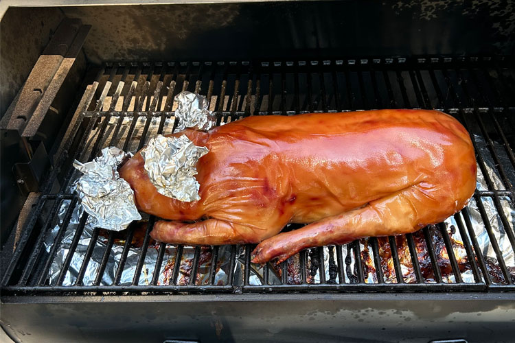cooked suckling pig on the smoker