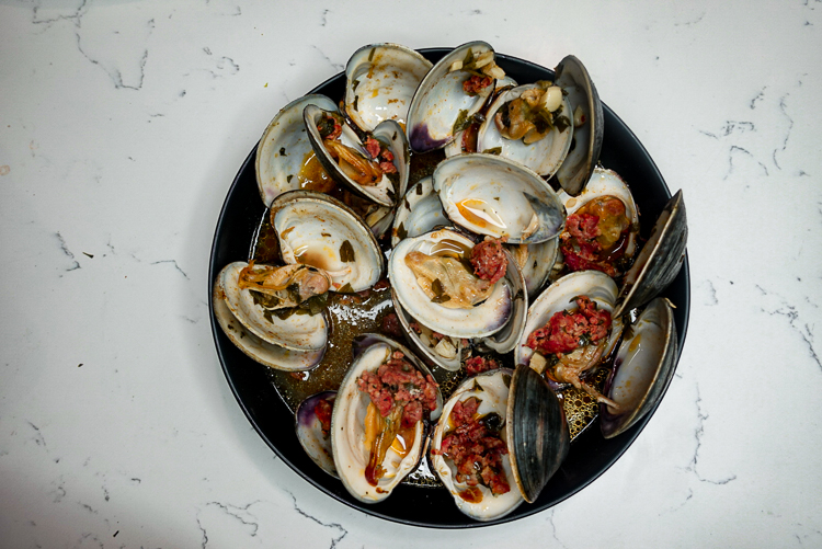 clams and chorizo in black bowl