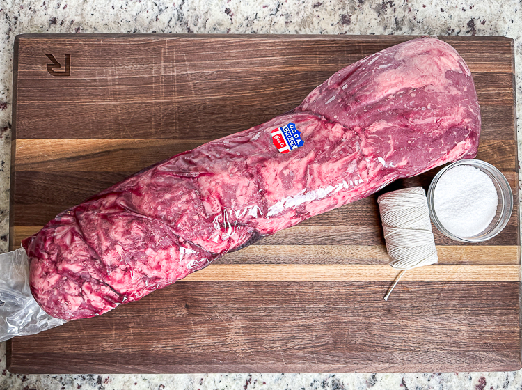 beef tenderloin in its packaging on a wooden board