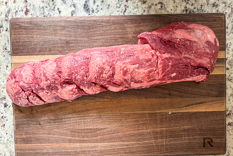 raw beef tenderloin on a wooden board