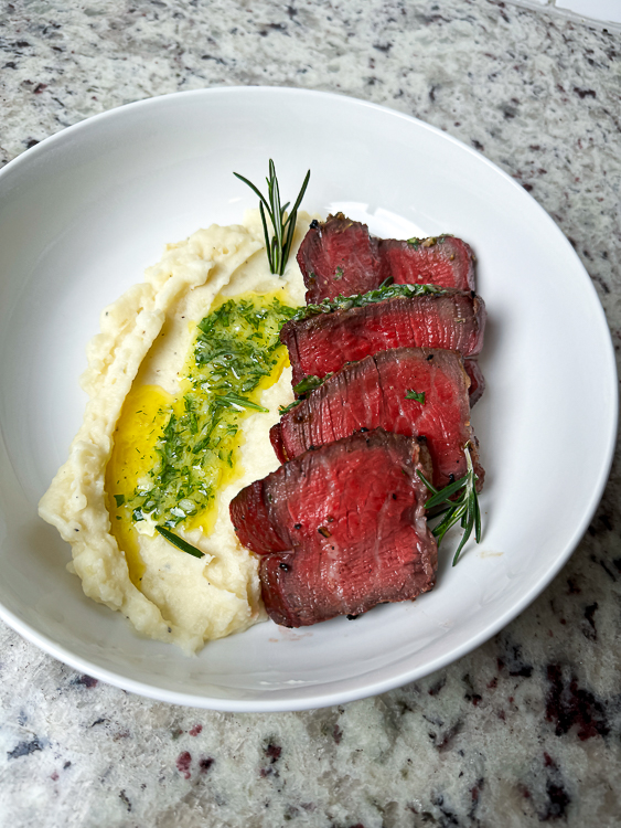 filet mignon sliced and plated with mash