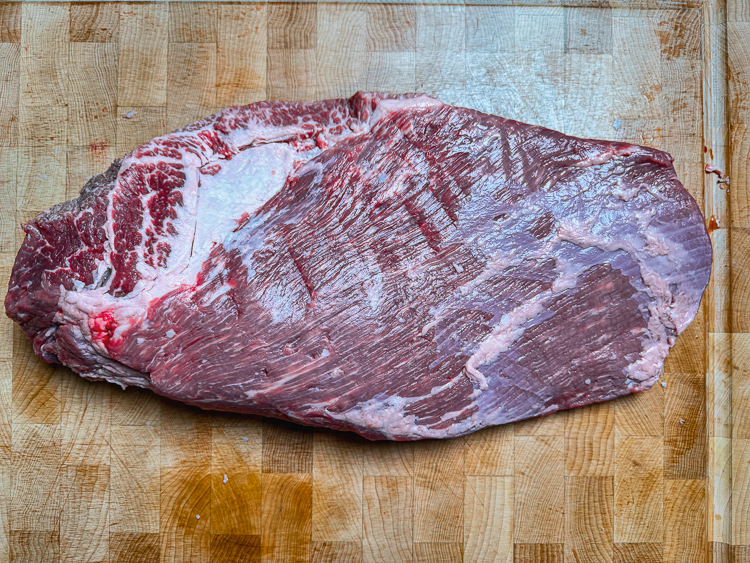 raw trimmed costco brisket on a wooden chopping board