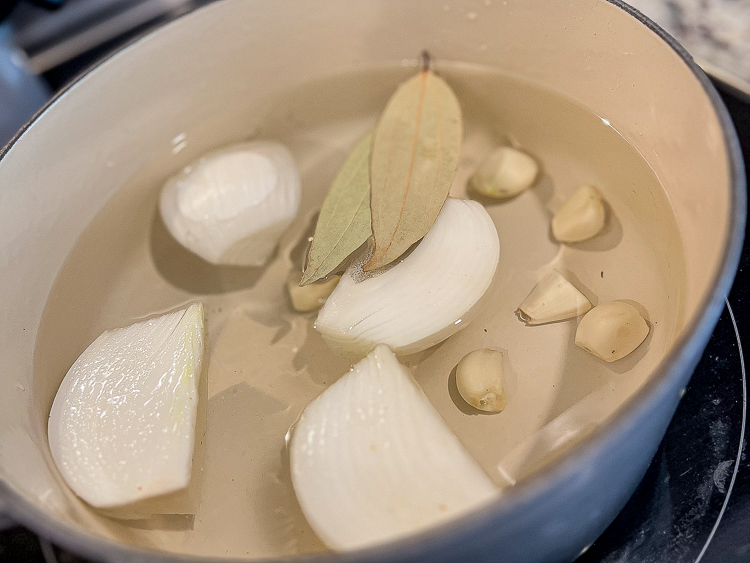 onions, garlic and bay leaves in a pot of water