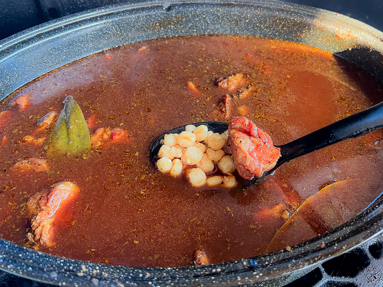 hominy being added to pot of pozole