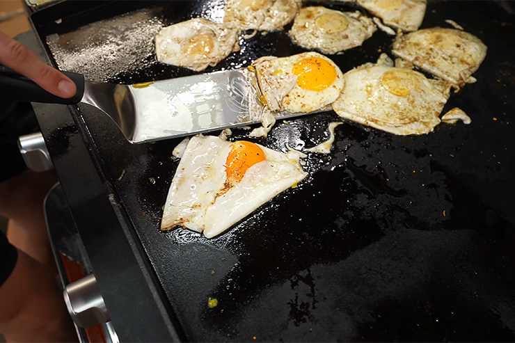 ma flipping eggs with long rounded edge spatula