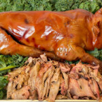 smoked suckling pig on bed of greens