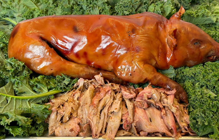 smoked suckling pig on bed of greens