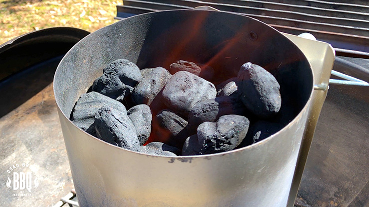 charcoal briquettes burning inside the chimney starter