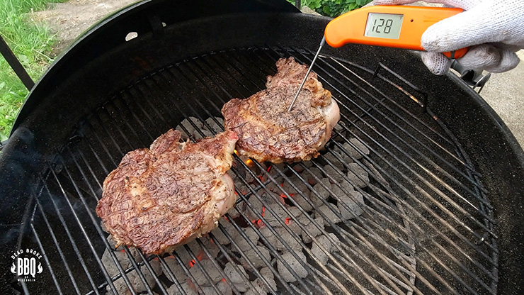 a person checking a steak internal temperature with an instant-read thermometer
