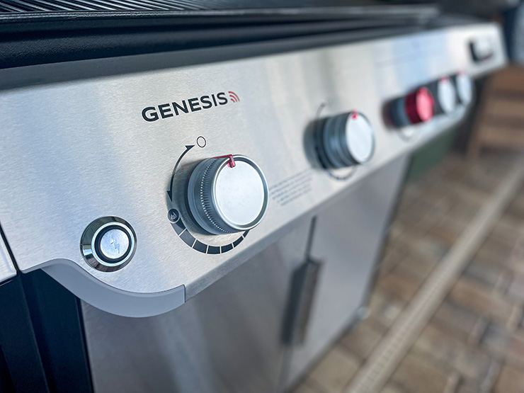a close up view of the electric igniter push button on the Weber Genesis propane grill