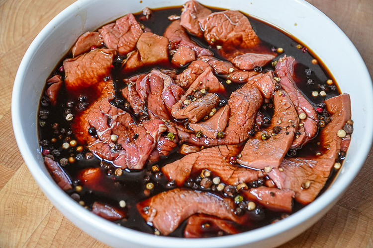 peppered beef in marinade in white bowl