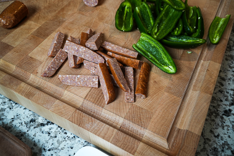 pieces of smoked pork sausage on a wooden chopping board