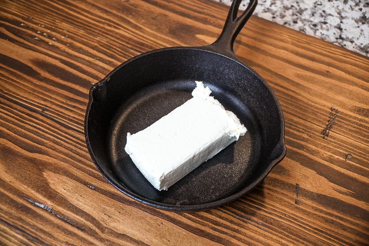 cream cheese block in cast iron skillet