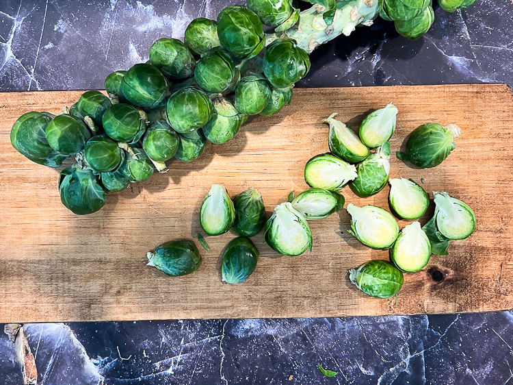 a wooden board with brussels sprouts cut in half