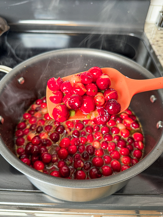 pot of cranberries with a wooden spoon