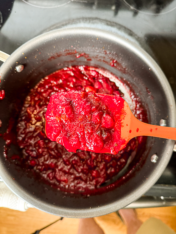 cranberry sauce in a pot with wooden spoon