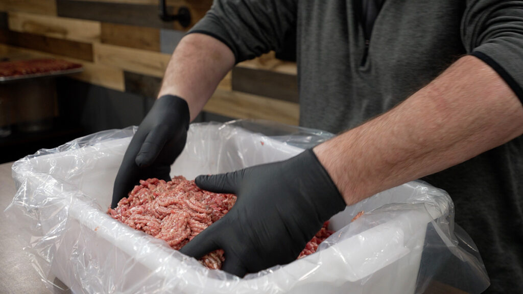 mixing breakfast sausage meat with black gloves