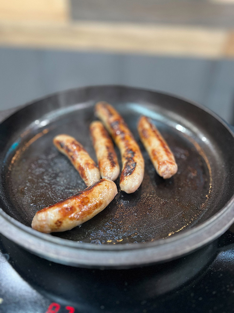 frying breakfast sausage in a pan