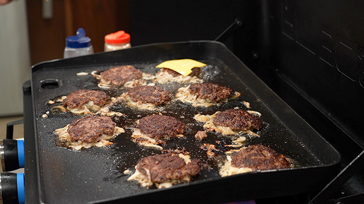 burger patties cooking on the Pit Boss Ultimate Lift Off Griddle