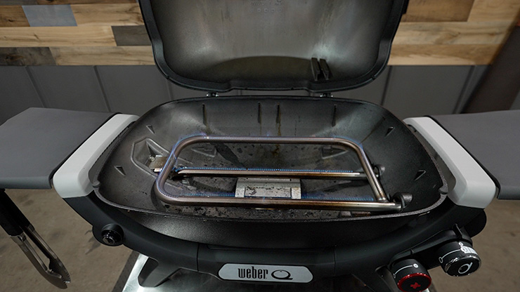 Weber Q Plus Gas Grill with 2 burners burning without the grill grates