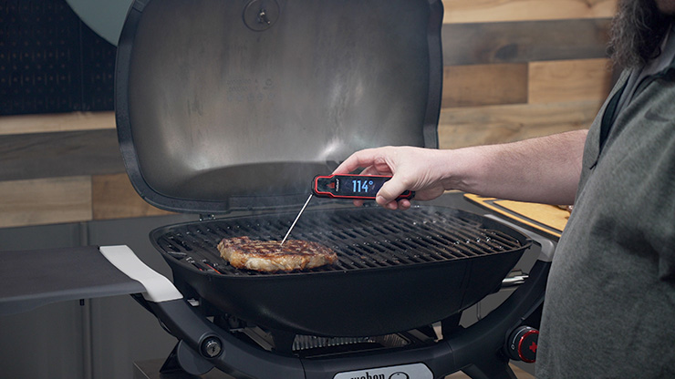 Jeff Rice checking a ribeye steak internal temperature with a meat thermometer
