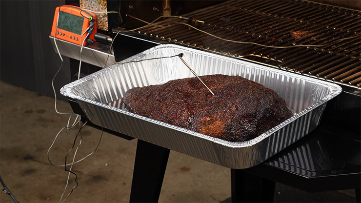 smoked brisket in a foil tray on the front shelf of the Pit Boss Pro 1600 Elite pellet grill