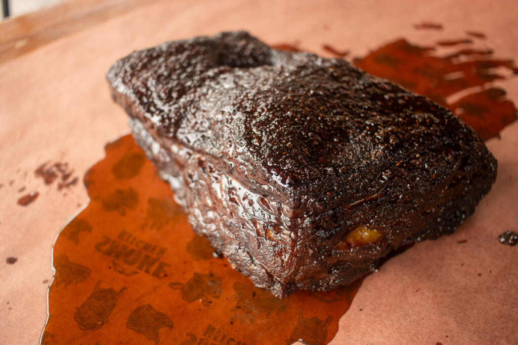 a piece of smoked beef belly on butcher paper with juices